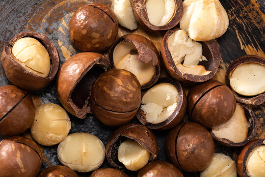 A bunch of macadamia nuts in an old wooden plate, top view