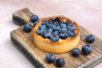 Blueberry pie on a wooden board. Blueberry tart. Berry dessert on a wooden background.
