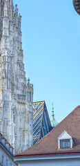 View of part of St. Stephen's Cathedral in Vienna and red tiled roof against blue sky with copyspace
