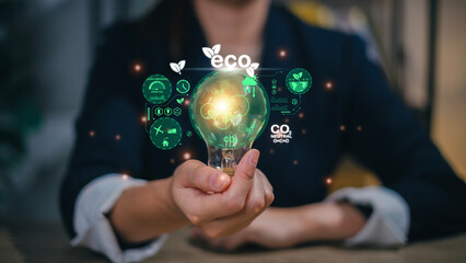 Businesswoman hand holding light bulb with ESG icon on virtual screen, ESG Environmental, social and corporate governance concept..
