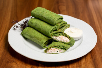 Green vegetarian spring rolls, vegetable food, spinach pancakes on a white plate. Healthy breakfast concept, restaurant menu
