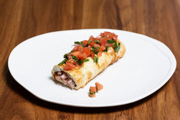 Baked bun with meat filling, decorated with tomatoes and herbs. Restaurant menu