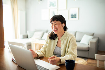 Young Japanese Woman working on a laptop in the kitchen