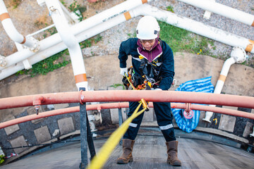 Focus top view male worker down height tank roof rope access safety inspection of thickness storage tank crude oil