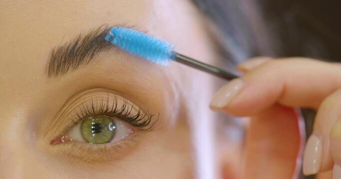 Woman making eyebrow correction. Close-up video.