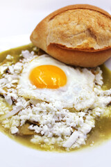 chilaquiles verdes con huevo estrellado. Comida mexicana. Desayuno mexicano. almuerzo mexicano, torilla, masa de maiz, tortilla frita, bolillo, crema y queso