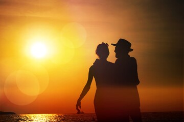 Silhouette sunset : Senior business man and his wife walking on the beach sunset ,Silhouette romance after retire happy life concept  scene marriage anniversary over sunset luxury and happiness moment