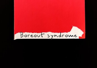 Torn red card on black background with handwritten word BOREOUT SYNDROME, employees don't feel...