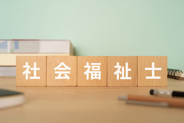 社会福祉士と書かれたブロックが置かれたデスク
