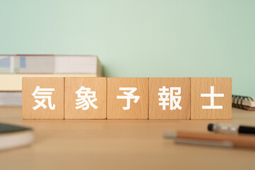 気象予報士と書かれたブロックが置かれたデスク