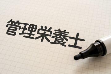 管理栄養士と書かれたノートとマーカー