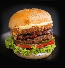 Street food, fast food. Homemade juicy burgers with beef, cheese and onions on a black background.