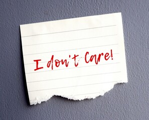 Ripped note paper on dark grey wall written I DON'T CARE indicates speaker has no interest or...