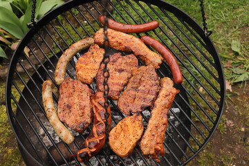 various meat and sausages on the charcoal grill