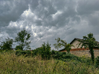 Dark stormy sky over a village house