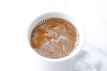 淹れたてのフレッシュなコーヒーにクリームを入れる