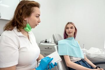 Obraz premium female doctor is client during a consultation with girl patient in dental clinic.