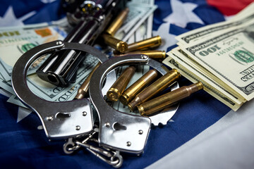 Obraz premium money gun with handcuffs casings against the background of an American flag lying carelessly