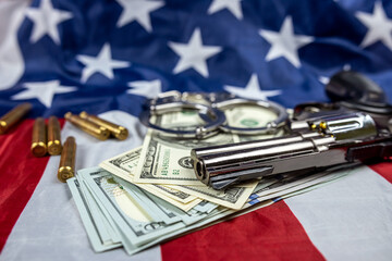 money gun with handcuffs  casings against the background of an American flag lying carelessly