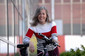 Cheerful middle-aged woman rides bicycles, recreation every day