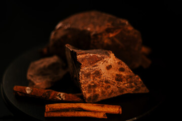 Chocolate. Chunks of dark chocolate rotate on dark background, rotate. Gourmet dessert ingredient. Confectionery, confection concept.