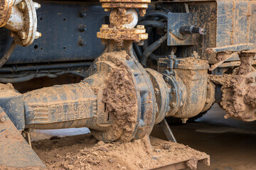 Plakat Photograph of a large valve and fittings covered in mud on a large water truck used for conditioning the surface on a dirt track speedway racetrack