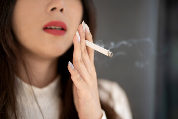 Young asian woman smoking. The drug is harmful to the respiratory system.