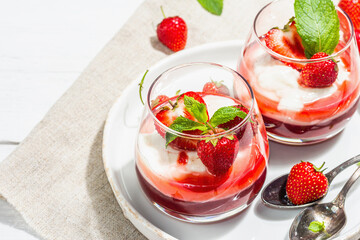 Italian dessert panna cotta in glass with strawberries. Healthy sweet food, hard light, dark shadow