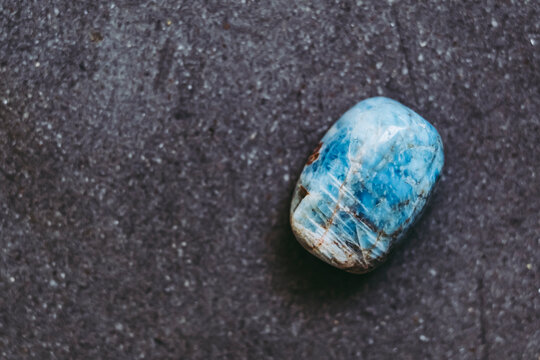 Galet pierre roul&eacute;e polie apatite sur un fond noir avec espace vide - Min&eacute;ral naturel	