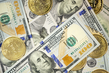 Gold Bitcoin on hundred dollars bills. Close-up
