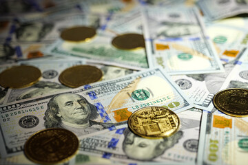 Gold Bitcoin on hundred dollars bills. Close-up