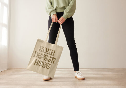 Mockup of customizable tote bag being modelled by woman, front view low section