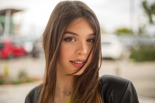 close-up of a young italian brunette woman with straight hair in a shopping mall parking lot for spring sale shopping