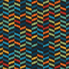 Seamless chevron pattern with embroidered rectangles in red, blue, yellow, and orange on a black background. Abstract geometric design. Graphic textile texture. Multicolor zigzag horizontal lines.
