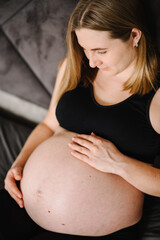 Pregnant woman. Pregnancy, motherhood, procreation concept. Closeup belly of woman. Female waiting for newborn baby. Young pregnant girl touching and holding belly and caring about health. Top view.