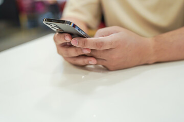 Relaxed young asian man using smart phone  spending time checking news social media.