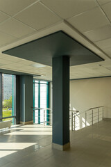 A large, spacious, empty room with huge windows and floor-mounted central heating radiators with temperature controllers.