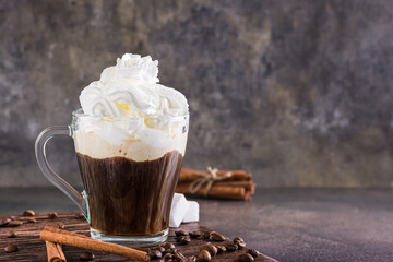 Mug of Viennese coffee with whipped cream and cinnamon on the table