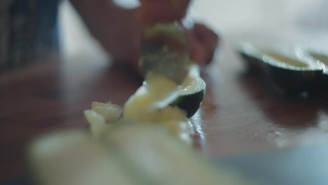 Removing inside of zucchini with a spoon. Slow motion, shallow depth of field.  
