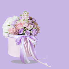 Floral concept. White, pink and purple flowers in a bouquet. Different flower on bouquet in a cylindrical box, levitation. Gentle lilac background. Birthday, Mother's Day banner. Copy space. Mockup.