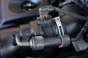 Fototapeta na wymiar Mass flow sensor. Air flow sensor. Car engine parts. Under the hood of a vehicle. Vehicle electronic engine control sensor.