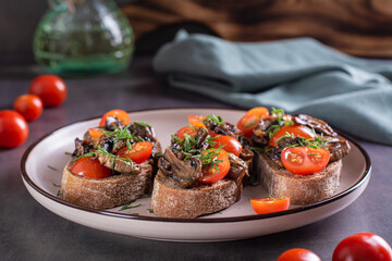 Appetizing sandwiches with fried mushrooms and tomatoes on rye bread on a plate