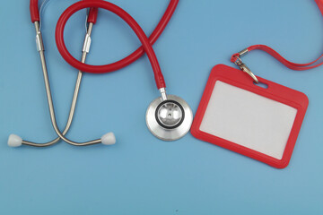 Red stethoscope and red blank badge on blue background. Medical events and meetings concept.