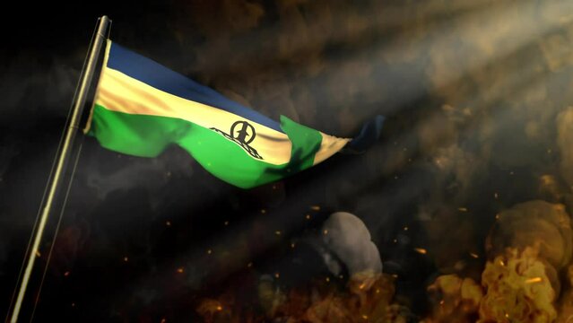 waving Lesotho flag on smoke and fire with sun beams - disaster concept