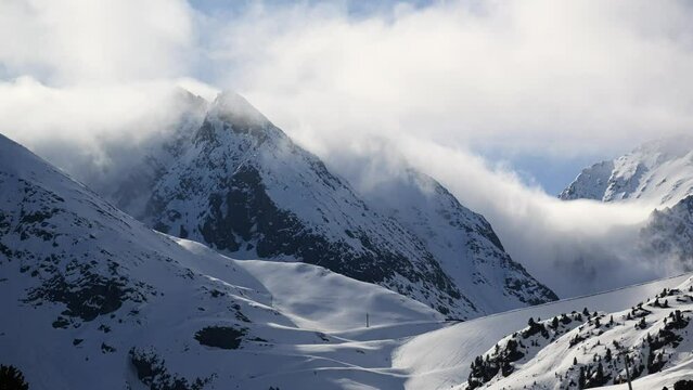 time lapse of clouds crawling over high snow covered mountain peaks in the Austrian Alps in Kuethai