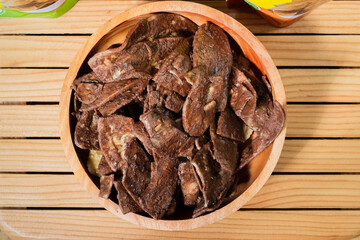 Banana chips with chocolate flavor made from raw bananas fried in a wooden bowl. Traditional snacks