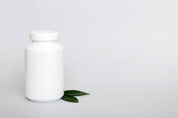 supplement pills with medicine bottle health care and medical top view. Vitamin tablets. Top view mockup bottle for pills and vitamins with green leaves, natural organic bio supplement, copy space