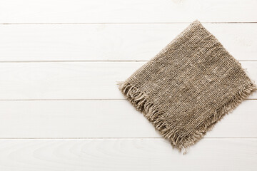 Old burlap fabric napkin, sackcloth on table background. top view with copy space