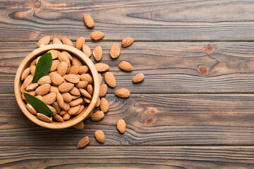 Fresh healthy Almond in bowl on colored table background. Top view