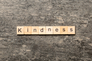 kindness word written on wood block. kindness text on table, concept